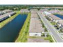 Community aerial view with townhomes lining a lake; lush landscaping and mature trees enhance the scene at 15164 Sunny Day Dr, Bradenton, FL 34211