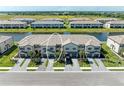 An aerial view of attractive townhomes along a lake with manicured landscaping at 15164 Sunny Day Dr, Bradenton, FL 34211