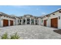 Attractive home featuring a wide paver driveway leading to a stunning entrance with multiple garage spaces at 15315 Anchorage Pl, Lakewood Ranch, FL 34202