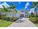 Beautiful two-story home with a paver driveway, lush landscaping, and a three-car garage at 17110 Verona Pl, Bradenton, FL 34202