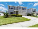Two-story home featuring a manicured lawn, stone accents, and a neutral color palette on a sunny day at 17209 Barnwood Pl, Bradenton, FL 34211