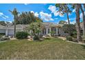 Beautiful home featuring a manicured lawn, mature landscaping, and a welcoming entrance at 2016 White Feather Ln, Nokomis, FL 34275
