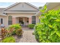 Close-up of a front entrance with well-maintained landscaping and a brick walkway at 2025 Lynx Run, North Port, FL 34288