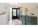 Inviting foyer featuring wood flooring, an updated light fixture, and a decorative cabinet at 204 Aspen St, Englewood, FL 34223