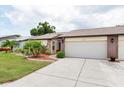 Charming single-story home with a well-manicured lawn and an attached two-car garage at 204 Aspen St, Englewood, FL 34223