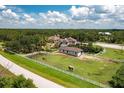 A horse grazes near the fenced perimeter of an estate, featuring a main house, a guest house, and an equestrian training area at 21210 77Th E Ave, Bradenton, FL 34202