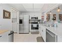Updated kitchen with stainless steel appliances, white cabinetry, and adjacent laundry at 2415 Bayshore Gardens Pkwy # 2, Bradenton, FL 34207