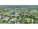 Scenic aerial view of a home nestled within a lush, green community with a golf course and serene lakes at 2761 Feiffer Cir, Sarasota, FL 34235