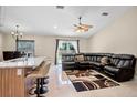 Open-concept living area with tile floors, ceiling fan, and kitchen bar at 2761 Feiffer Cir, Sarasota, FL 34235