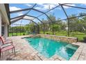 Screened-in pool area featuring a sparkling pool, a hot tub, and manicured landscaping at 2920 Oriole Dr, Sarasota, FL 34243