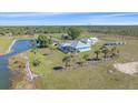 Beautiful aerial view of the house, surrounded by lush greenery, a pond, and a wooden perimeter fence at 29527 Leah Rd, Punta Gorda, FL 33982