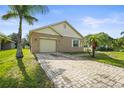 Charming single-story home with a brick paver driveway and well-maintained lawn with a palm tree in front yard at 3362 Howell Pl, Sarasota, FL 34232