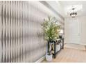 Beautiful foyer featuring stylish wallpaper, wood floors, modern light fixture, and accent furniture at 3621 Wild Blossom Pl, Parrish, FL 34219
