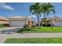 Beautiful home featuring a well-manicured lawn, vibrant landscaping, and attached two-car garage at 4200 Reflections Pkwy, Sarasota, FL 34233