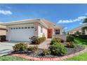 Beautiful home featuring a well-manicured lawn, vibrant landscaping, and attached two-car garage at 4200 Reflections Pkwy, Sarasota, FL 34233