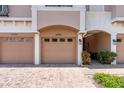 Close-up shot of garage doors in a townhome complex with brick driveway and well-maintained landscaping at 4235 Overture Cir # 4235, Bradenton, FL 34209
