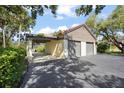 Detached two-car garage featuring ample parking space, complemented by mature trees and shrubs at 4333 Trails Dr # 10-1, Sarasota, FL 34232