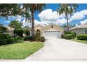 Beautiful single-story home featuring a manicured lawn, mature palm trees, and a convenient two-car garage at 4374 Mirabella Cir, Bradenton, FL 34210
