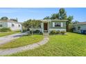 Inviting single-story home with a well-manicured lawn, mature tree, and quaint facade at 5028 Oxford N Ave, St Petersburg, FL 33710