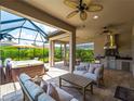 Screened outdoor living area with a hot tub, outdoor kitchen, and comfortable seating at 5364 Salcano St, Sarasota, FL 34238