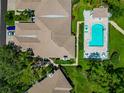Aerial view of a home with a private pool, lush landscaping, and a tile roof at 5417 Champagne # 63, Sarasota, FL 34235