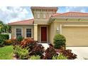 Inviting front entrance with a red door and lush landscaping creating a warm curb appeal at 6214 45Th E Ln, Bradenton, FL 34203