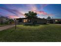 Inviting exterior of a single-story home with lush green lawn and mature trees in a peaceful setting with a lovely sunset at 6707 Northampton Pl, Bradenton, FL 34207