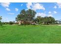 A lush green lawn surrounds a home with mature trees and landscaping at 6805 225Th E St, Bradenton, FL 34211