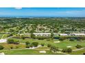 Aerial view of building surrounded by a lush green golf course and a blue body of water at 7461 W Country Club N Dr # 206, Sarasota, FL 34243