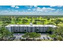 Aerial view of building near golf course with lush green fairways and blue skies at 7461 W Country Club N Dr # 206, Sarasota, FL 34243