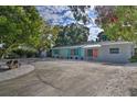 Charming single-story home boasting a spacious driveway and colorful accents with lush surrounding trees at 7511 1St W Ave, Bradenton, FL 34209