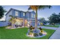 Gorgeous two-story home featuring a well-manicured lawn, a three-car garage, and a welcoming front porch at 7915 115Th E Ave, Parrish, FL 34219