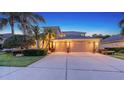 Well-lit home exterior showing the front yard, driveway and three car garage at 7915 Kavanagh Ct, Sarasota, FL 34240