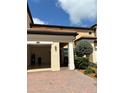 Home's exterior showing open garage, brick driveway and well maintained landscaping and exterior at 10054 Crooked Creek Dr # 201, Venice, FL 34293