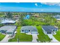Aerial view of canal-front homes showcases the waterfront community and manicured lawns at 10443 Riverside Rd, Port Charlotte, FL 33981