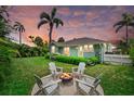 Inviting backyard with a fire pit surrounded by chairs, creating a cozy outdoor gathering space at 1051 Indian Beach Dr, Sarasota, FL 34234