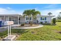 Charming single-story home with a well-manicured lawn, complemented by vibrant blue shutters and a convenient carport at 107 Clipper Way # 107, Nokomis, FL 34275