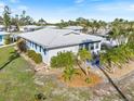 Beautiful exterior view of home surrounded by lush landscaping, palm trees and manicured garden beds at 107 Clipper Way # 107, Nokomis, FL 34275