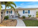 Close up of a house with blue shutters and a sidewalk leading to the front door with decorative accents at 107 Clipper Way # 107, Nokomis, FL 34275