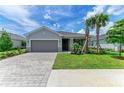 The home features a manicured lawn, stone accents, a paved driveway, and a two-car garage at 11327 Burgundy Dr, Venice, FL 34293