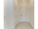 The home's entrance with gray tiling and contemporary lighting at 11327 Burgundy Dr, Venice, FL 34293