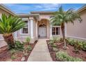 Inviting front entrance featuring double doors, columns, and lush tropical landscaping at 11328 Rivers Bluff Cir, Lakewood Ranch, FL 34202
