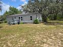 Exterior shot of the home and yard with ample space and mature trees at 13023 Taylor St, Brooksville, FL 34613