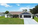Inviting single-story home featuring a neatly maintained lawn, complementing the home's exterior at 1498 Truval Ter, Port Charlotte, FL 33952