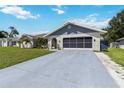 Beautiful single-story home with an attached garage and a well-kept driveway and lawn at 1498 Truval Ter, Port Charlotte, FL 33952