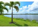 Expansive backyard featuring lush grass and a serene lake view, perfect for outdoor activities and relaxation at 17320 Polo Trl, Bradenton, FL 34211