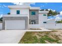 Contemporary home featuring a clean white facade, gray accents, and a wide driveway at 2065 Goldenrod St, Sarasota, FL 34239