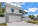 Modern two-story home featuring a clean white facade, gray accents, and a wide driveway at 2065 Goldenrod St, Sarasota, FL 34239