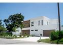 Contemporary home with a manicured lawn, showcasing clean lines and a modern design at 2124 Clematis Pl, Sarasota, FL 34239