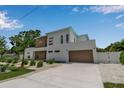 Modern two-story home with manicured lawn, concrete driveway, and neutral color palette at 2124 Clematis Pl, Sarasota, FL 34239